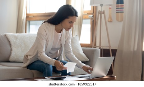 Easy To Pay. Thoughtful Young Businesswoman Sitting On Couch By Computer Checking Account Online Using E-banking App, Focused Millennial Female Paying Monthly Bills Taxes From Home Office By Internet