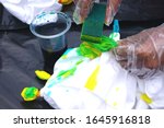 Easy tie-dye making process using plain white fabric and blue and yellow dyes in Indonesia