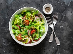 Easy Vegetarian Vegetable Salad With Fresh Vegetables. Cherry Tomatoes , Romano Lettuce, Cucumbers, Radishes And French Mustard, Olive Oil, Lemon Salad Dressing On A Dark Background, Top View         