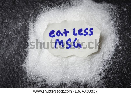 Eat less or stop monosodium glutamate no MSG for health concept / Heap of white monosodium glutamate on dark background 