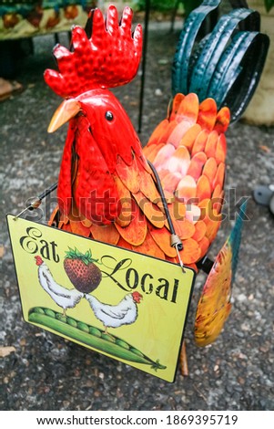 Eat Local sign on rooster sculpture