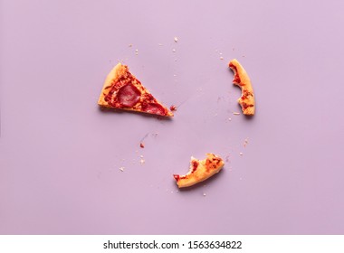 Eaten Pizza Concept With Just One Slice Of Salami Pizza And Crust Leftovers On A Purple Background. Above View Of Devoured Italian Pizza Pepperoni.