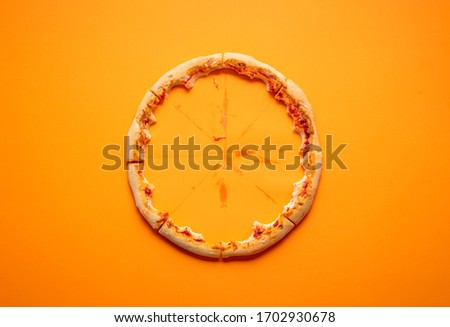 Eaten pizza context with pizza crust leftovers on an orange seamless background. Devoured pizza. Italian delicious food. Popular finger food.