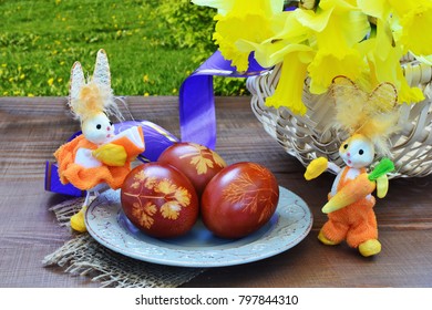 Eater scene with Easter eggs, daffodil flowers in basket and toy bunnies