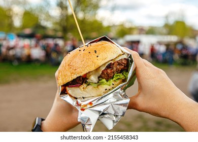 Eating burgers at an outdoor street food festival.