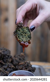 Eating. Closeup View Of A Female Caucasian Hand Dipping A Spinach Fritter In Ketchup Sauce, In The Restaurant. 