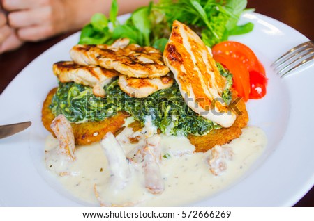 Eating delicious chicken with spinach and potato pancakes