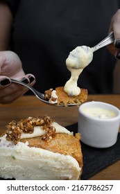 Eating Dessert. Closeup View Of A Woman's Hand Holding A Spoon With Carrot Cake And Passion Fruit Mousse. 