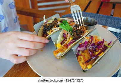 Eating Fish Tacos With Black Beans