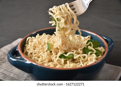 Eating A Forkful Of Raman Noodles Out Of A Bowl