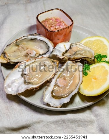 Eating of fresh big raw Zeeuwse Creuse Dutch oysters from Zeeland with marinated onion, Netherlands