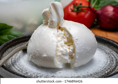 Eating Of Fresh Handmade Soft Italian Cheese From Puglia, White Balls Of Burrata Or Burratina Cheese Made From Mozzarella And Cream Filling Close Up