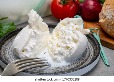 Eating Of Fresh Handmade Soft Italian Cheese From Puglia, White Balls Of Burrata Or Burratina Cheese Made From Mozzarella And Cream Filling Close Up