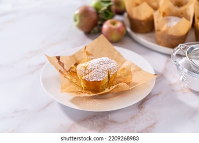 Eating freshly baked apple sharlotka muffin dusted with powdered sugar. - Shutterstock ID 2209268983