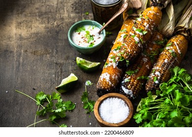 Eating Grilled Corn Cobs With Fresh Herbs,lime,beer And Salsa.