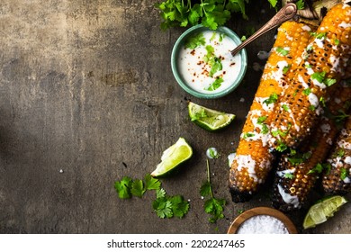 Eating Grilled Corn Cobs With Fresh Herbs,lime,beer And Salsa.