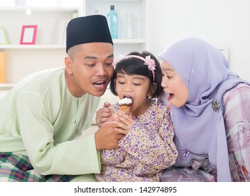 Eating Ice Cream. Muslim Family Sharing An Ice Cream. Beautiful Southeast Asian Family Living Lifestyle At Home.