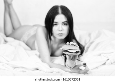 Eating Junk Food In Bed. Girl In Sexy Lingerie Eat Burger. Sexual Appetite. Food Delivery Service. Seductive Sexy Woman Relax On Bed. Diet Concept. Fast Food. Seductive Woman Hungry. Lazy Day Food.