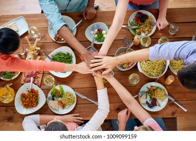 Eating And Leisure Concept - Group Of People Having Dinner And Holding Hands Together Over Table With Food