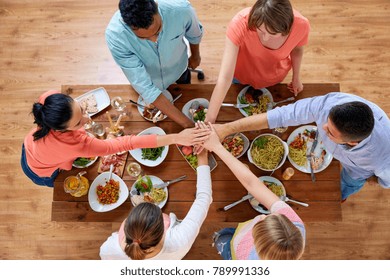 Eating And Leisure Concept - Group Of People Having Dinner And Holding Hands Together Over Table With Food