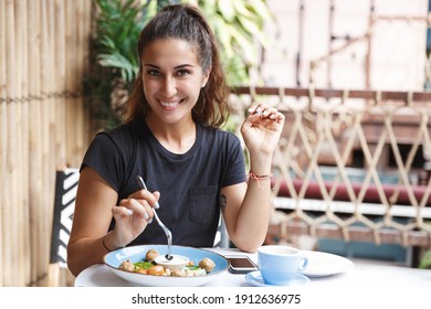 Eating Out, Lifestyle And Travelling Concept. Portrait Of Pretty European Woman Eating At Restaurant Table Healthy Food, Drinking Coffee, Dining Alone, Smiling, Tourist At Cafe Of Her Hotel.