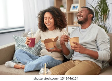 Eating And People Concept - Happy African American Couple With Takeaway Food And Drinks At Home