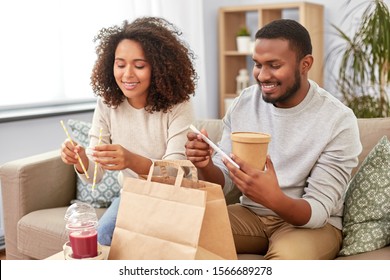 Eating And People Concept - Happy African American Couple With Takeaway Food And Drinks At Home