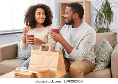 Eating And People Concept - Happy African American Couple With Takeaway Food And Drinks At Home