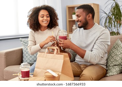 Eating And People Concept - Happy African American Couple With Takeaway Food And Drinks At Home