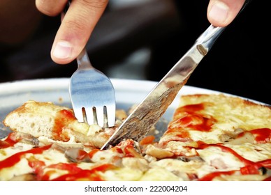 Eating Pizza Closeup With Knife And Fork