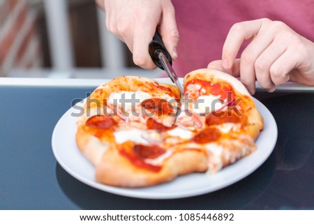 Eating pizza cooked on outdoor gas grill.
