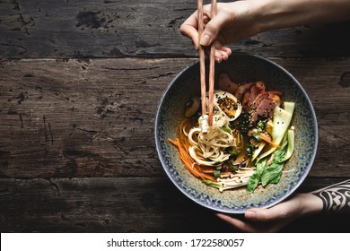 Eating ramen soup with noodles, pork, marinated egg and vegetables, top view. - Powered by Shutterstock