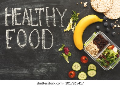 Eating right, storage and dieting conceptual background. Assortment of organic meals in plastic containers on black chalk board with healthy food inscription and copy space, top view - Shutterstock ID 1017265417