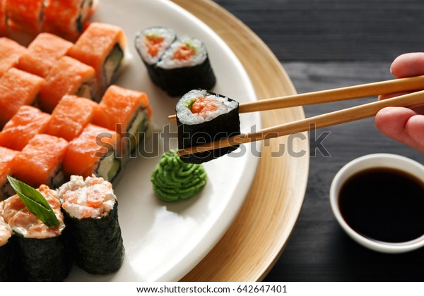 料理店で巻き寿司を食べ 箸を手に接写 女性が食事をする の写真素材 今すぐ編集