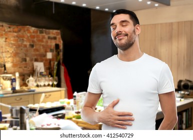 Eating, Satisfaction And People Concept - Happy Full Man Touching His Tummy Over Kitchen Background