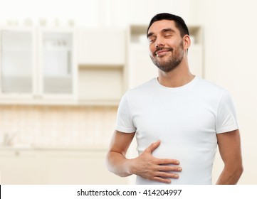 Eating, Satisfaction And People Concept - Happy Full Man Touching His Tummy Over Kitchen Background