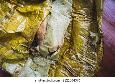 Eating Tamales In Oaxaca, Mexico. The Tamale Is Masa Filled With Mole Negro And Chicken Wrapped In A Banana Leaf.