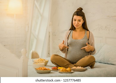 Eating A Lot While Pregnant. The Pregnant Woman Eating A Lot Of Different Food