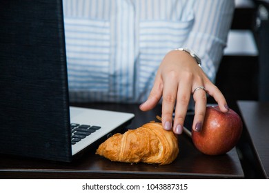 Eating At Work, Compulsive Eating, Tea Time Coffee Break At Office. Female Businesswoman Eat Croissant And Apple With Big Mug Of Hot Drink.