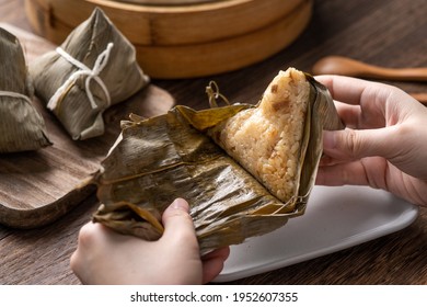 Eating Zongzi rice dumpling for Chinese traditional Dragon Boat Festival (Duanwu Festival) celebration event concept.