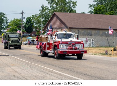 Eau Claire MI USA, July 4 2022, An Antique Fire Engine Decked Out With American Flags, Is Followed By An Old Army Truck, In This 4th Of July Parade