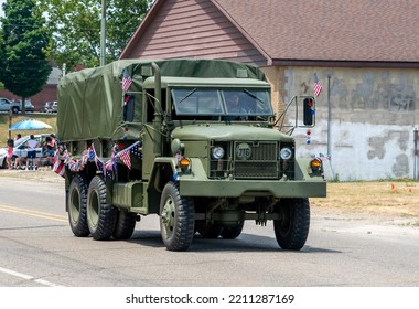 Eau Claire MI USA, July 4 2022; An Old Green Army Truck Is Decorated With American Flags, As It Drives In A 4th Of July Parade