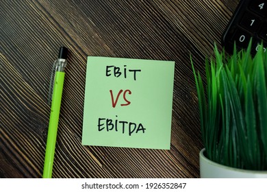Ebit Vs Ebitda write on sticky notes isolated on Wooden Table.