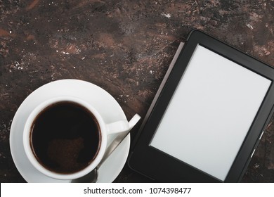E-book and paper books on the table with a cup of coffee, a laptop and reading glasses. Concepts of self-education. - Shutterstock ID 1074398477