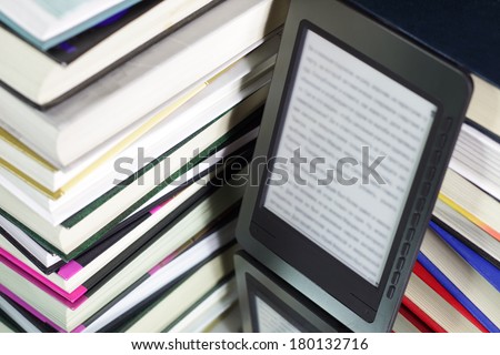E-book reader against the background of a stack books