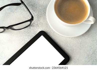 E-book reader, cup of coffee and glasses on gray surface - Shutterstock ID 2364564121