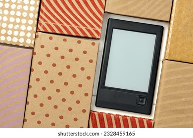 E-book reader device on background of paper books