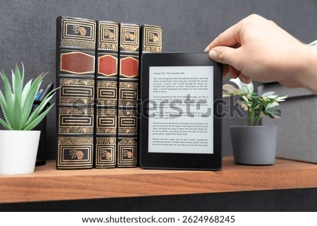 E-book reader device on shelf in home library