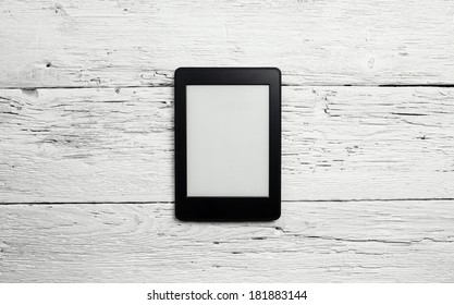 E-book reader or tablet pc on wooden background