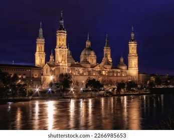 The Ebro river runs mighty between the bridges of Zaragoza, Spain, with the Basilica del Pilar de Testigo